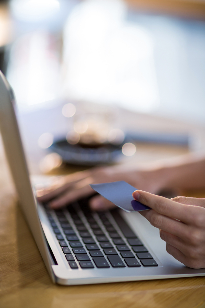 Woman doing online shopping on laptop in cafx92xA9